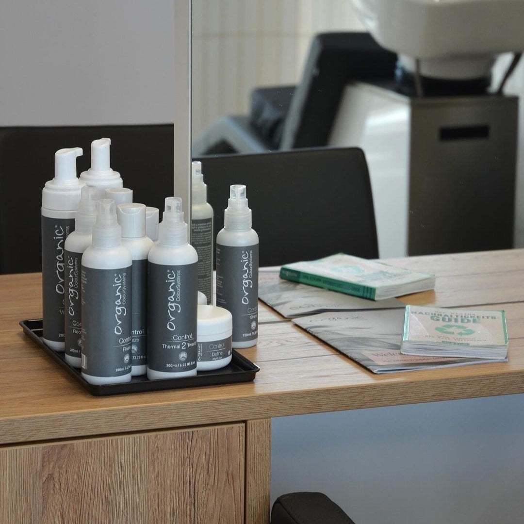 Several Organic Colour Systems control styling products placed on a shelf in a salon